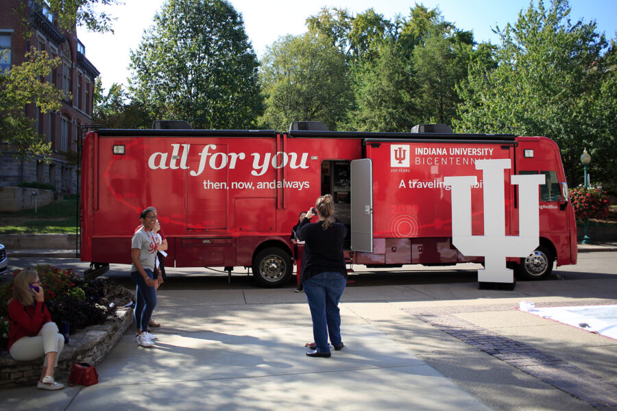 People outside of parked IU's traveling "Big red bus" Bicentennial exhibit