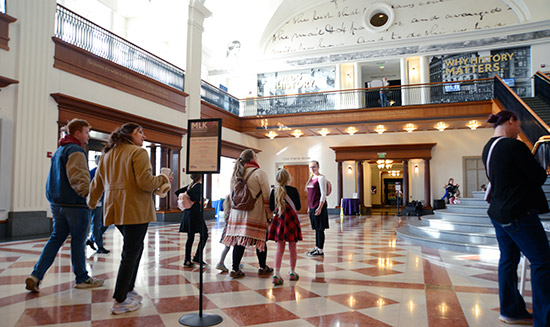 Visitors to the Indiana Historical Society walk through Lilly Hall, looking up at exhibits on surrounding mezzanine walls
